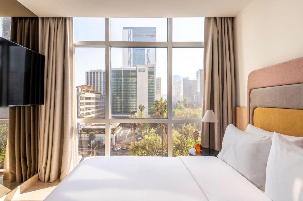 a hotel room with a bed and a large window at Hyde Mexico City Reforma in Mexico City