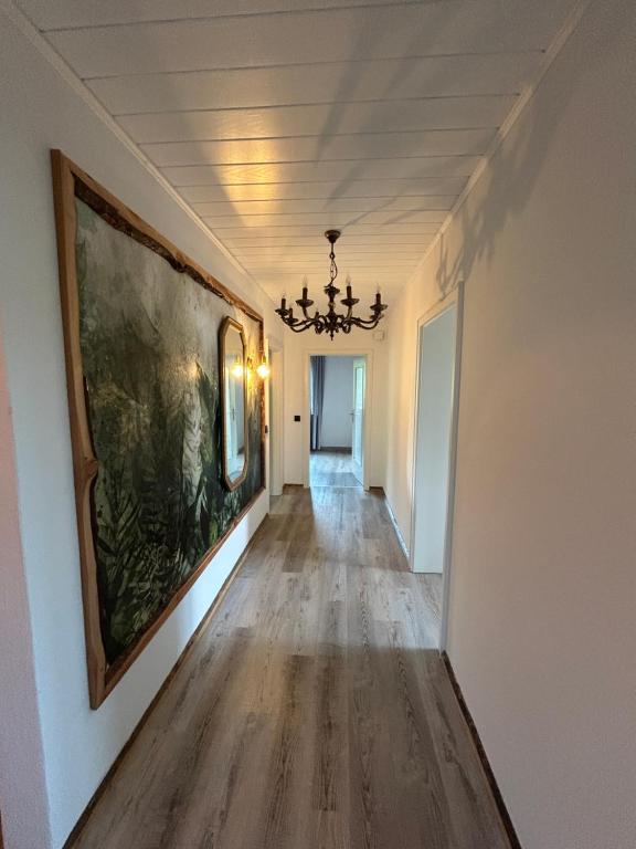 a hallway with a painting on the wall and a chandelier at Haus am Skywalk 3L in Beverungen