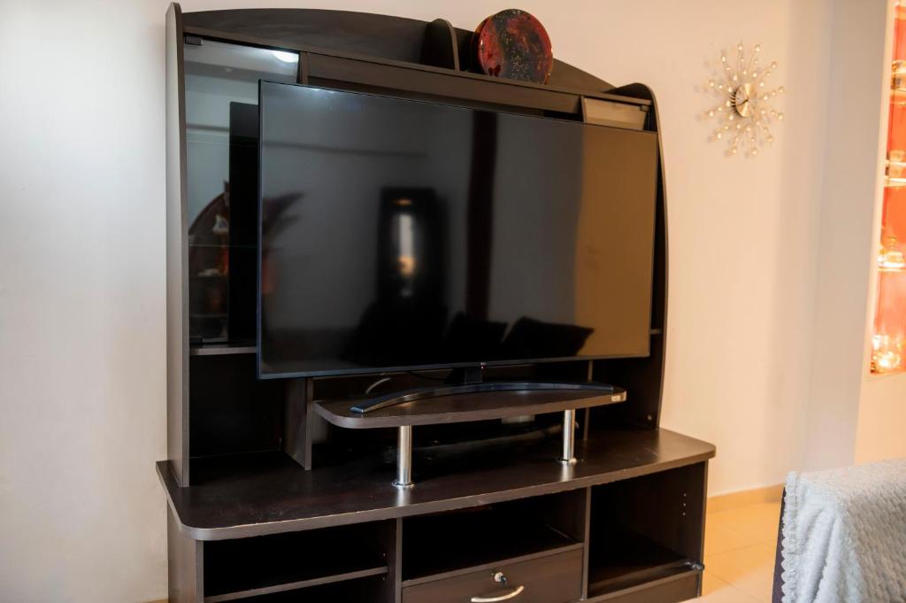a black entertainment center with a large flat screen tv at Dolphins maisonette Rhodes in Ialysos