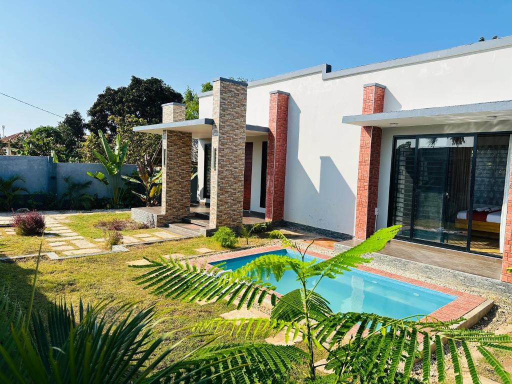 a house with a swimming pool in the yard at Shubbys Villa in Dar es Salaam