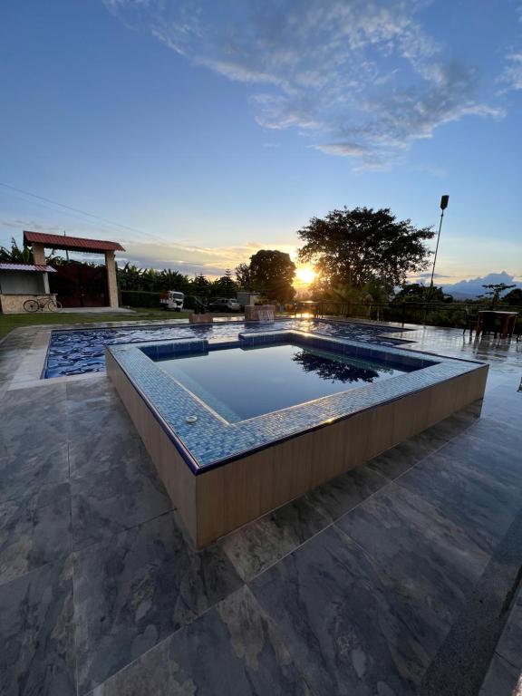 a swimming pool with a fountain in the middle at Tangara Real Hotel Campestre in Quimbaya