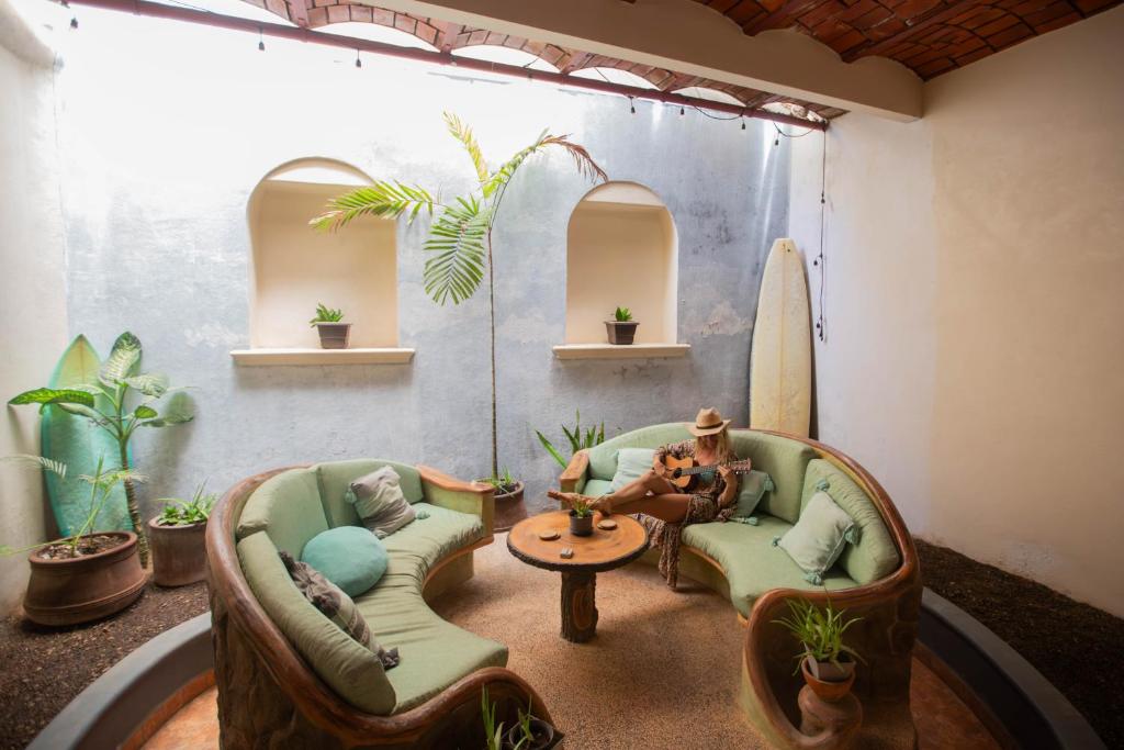 a room with two chairs and a table and a surfboard at Casa Carmela in Sayulita
