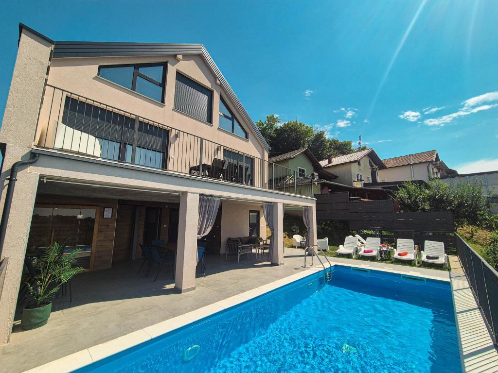 a house with a swimming pool in front of a house at Casa Kapela in Donji Koncovčak