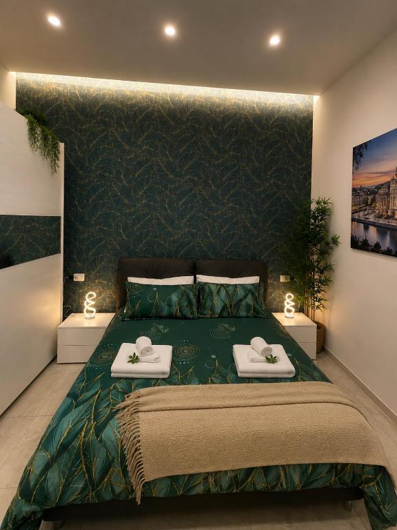 a bedroom with a large green bed with two white towels at Nigalù House in Naples
