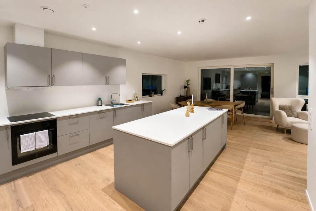 a kitchen with white cabinets and a living room at The View - 4BR Central Voss - The Voss Collection in Vossevangen