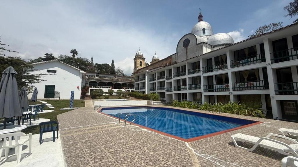 a hotel with a swimming pool in front of a building at Hotel Turístico de Tenza in Tenza