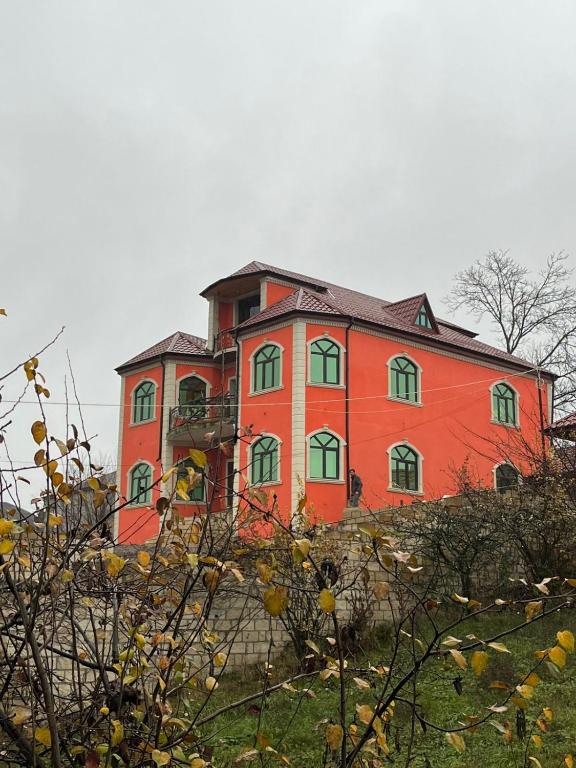 ein großes rotes Gebäude auf einem Hügel in der Unterkunft Zirvə in Quba