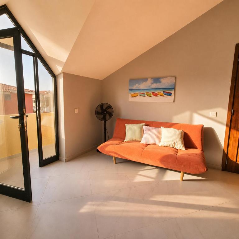 an orange couch in a living room with a window at Portal de Santa Maria in Santa Maria