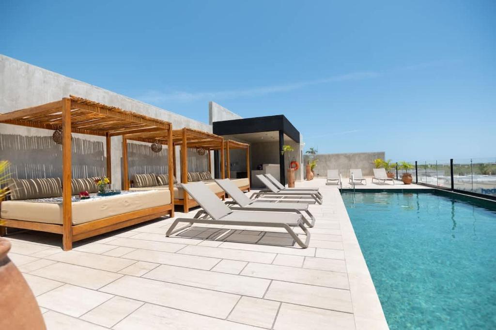 a pool with chaise lounge chairs and a swimming pool at Interior designers second home FREE BIKES in Tulum