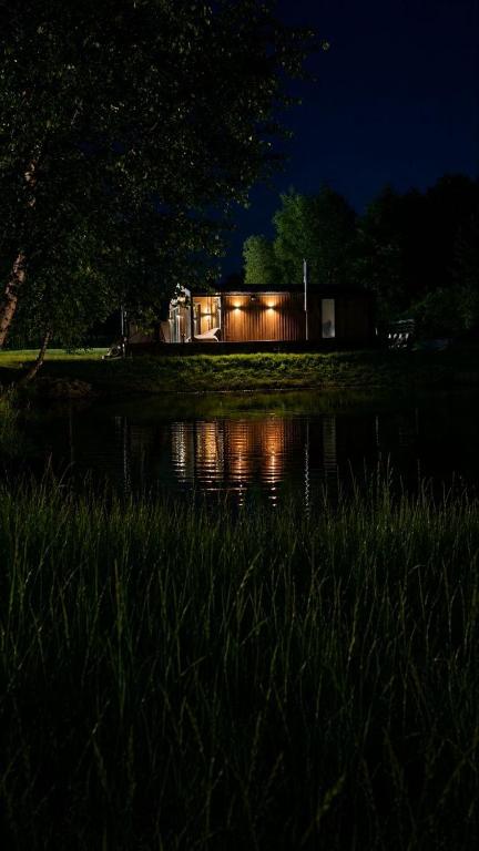a house is lit up at night next to a pond at SHKLO Lake&SPA in Shklo