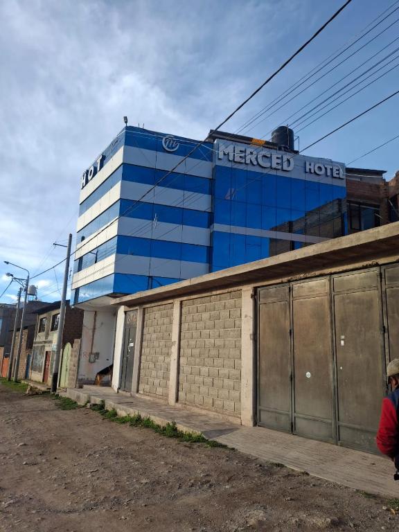 ein blaues Gebäude mit der Aufschrift „Merced Hotel“ in der Unterkunft Hotel Merced Macusani in Macusani