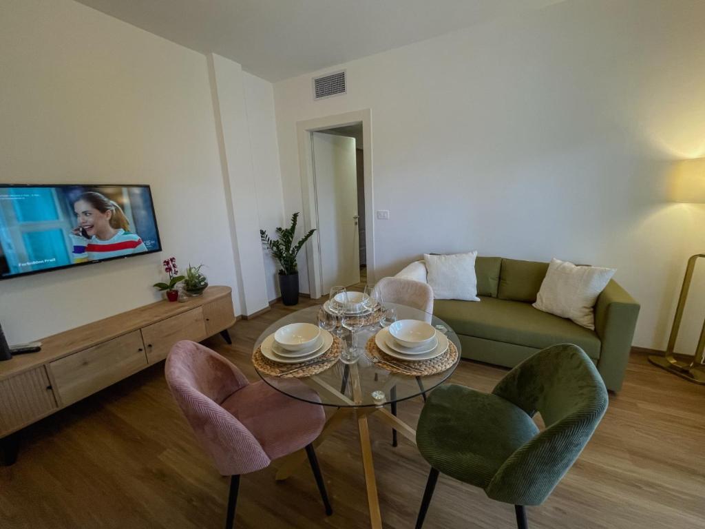 a living room with a table and chairs and a couch at Apartment-alys in Pordenone