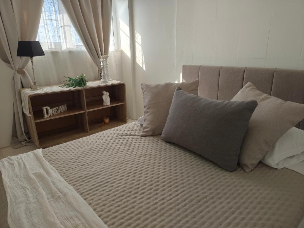 a bedroom with a bed with pillows and a window at Panora House in Kefalos