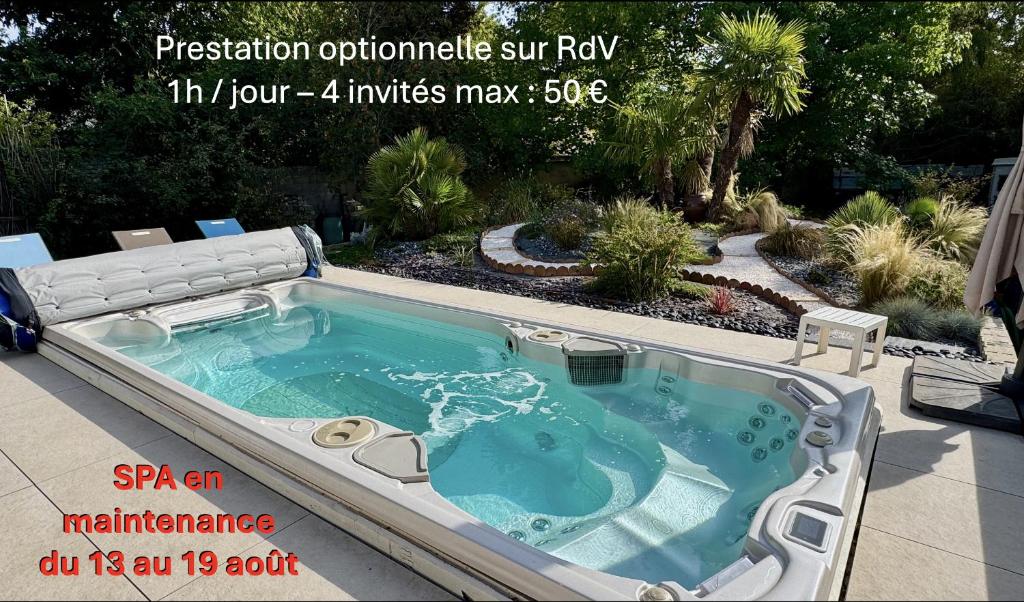 a jacuzzi hot tub in a landscaped yard at Millygite Chalet-on-wheels by the river in Milly-la-Forêt