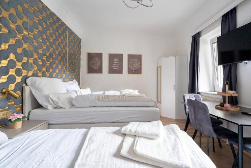 a hotel room with two beds and a desk and a desk at Apartment at Main Square - 35 m2 - Netflix - Quiet in Leoben