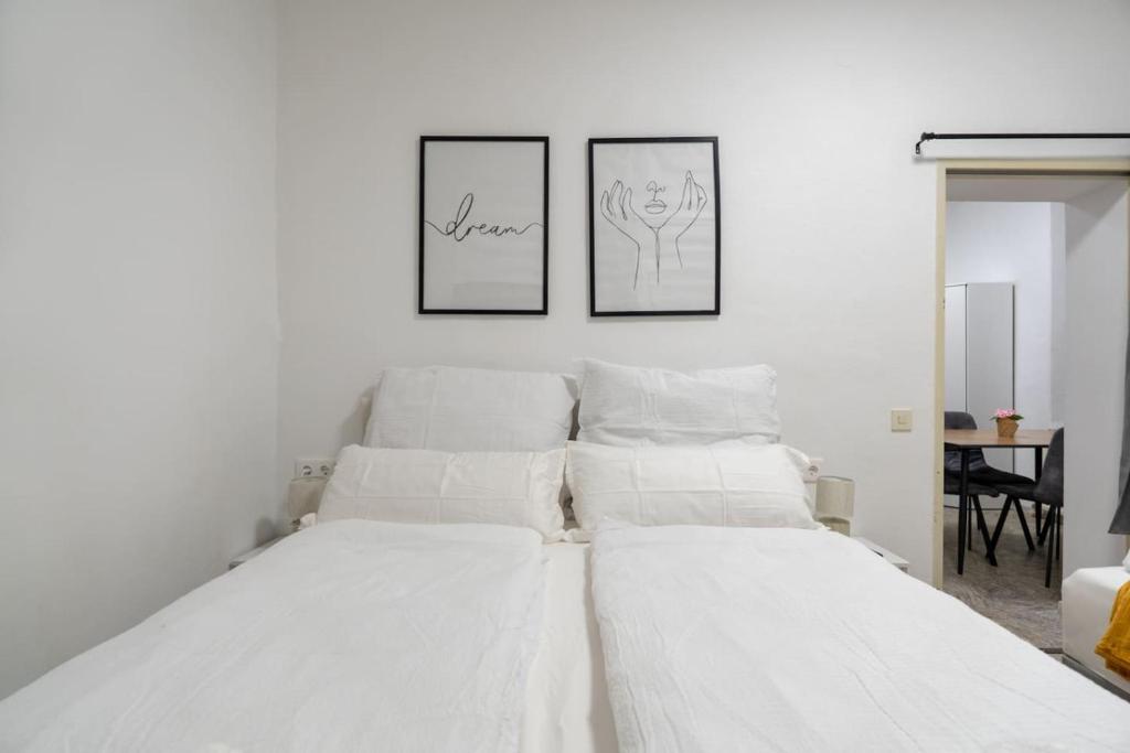 two beds in a bedroom with two pictures on the wall at Quiet - 4 Guests - Self Check-in - Netflix - 35m2 in Leoben