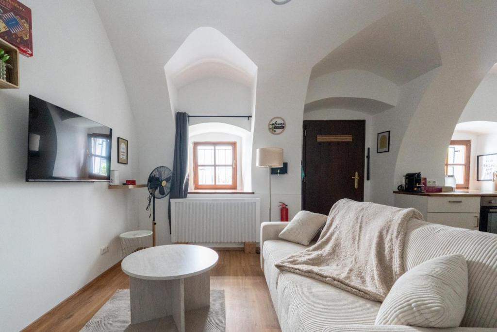 a living room with a white couch and a table at Coyhomes Steyr Riverside - Serviced Apartments in Steyr