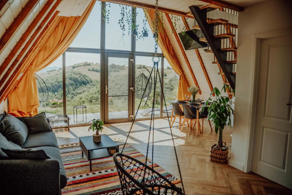 ein Wohnzimmer mit großem Fenster und Sofa in der Unterkunft Wild Hill Frames in Holbav