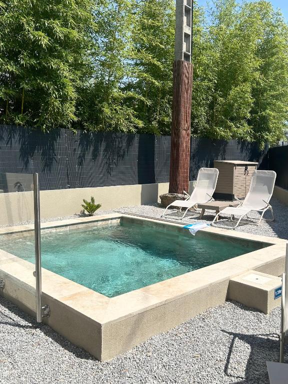 a swimming pool with two chairs and a poolvisorvisorangering at La villa Bern in Sorgues