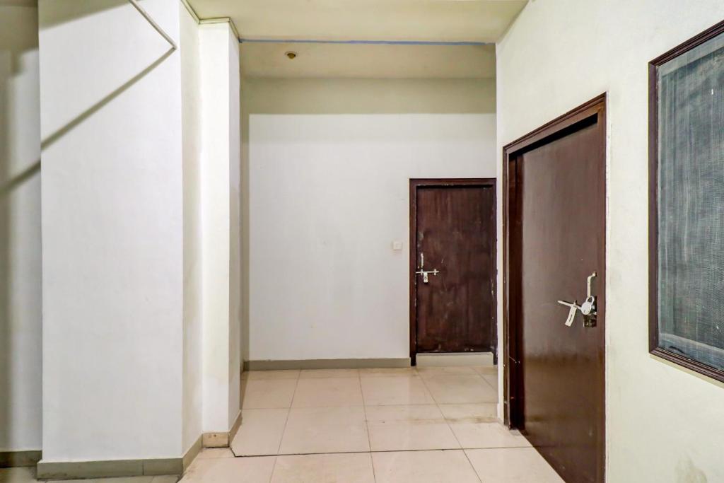 a hallway with a door and a tile floor at Hotel O by OYO Dhruv Inn in Izatnagar