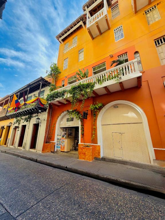 an orange building with a garage on a street at Hotel Marie Real Cartagena in Cartagena de Indias