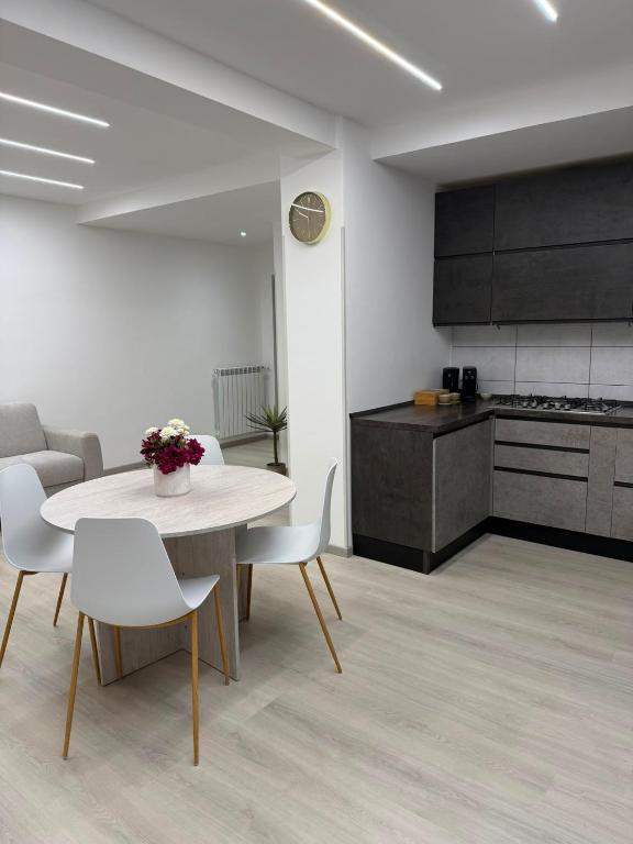 a room with a table and chairs and a kitchen at XIII Tempio in Cisterna di Latina