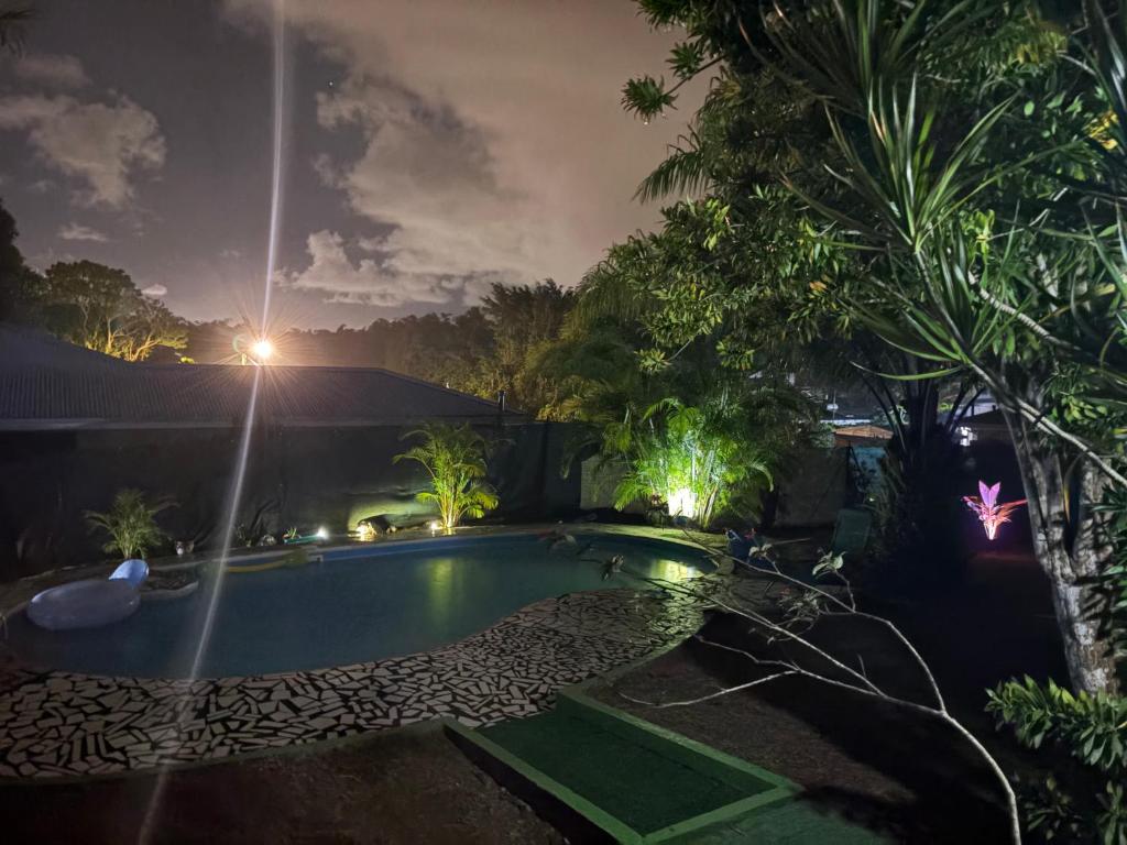 a swimming pool in a yard at night at Maison créole avec piscine et accès à la rivière in Lamentin