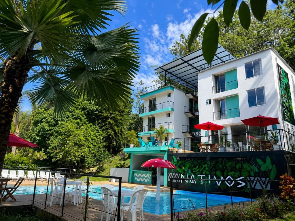 a hotel with a swimming pool and a building at HOTEL NATIVOS in La Vega