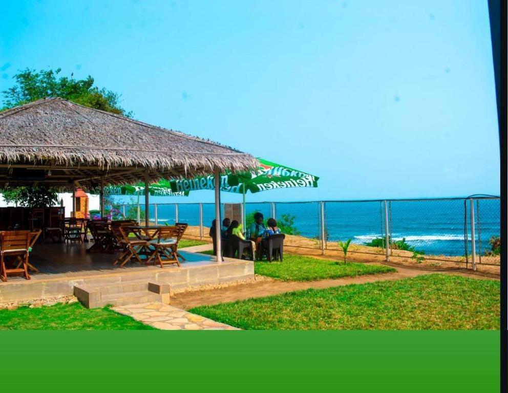 ein Restaurant mit Tisch und Stühlen und dem Meer in der Unterkunft Hotel Atlantic View in Muanda