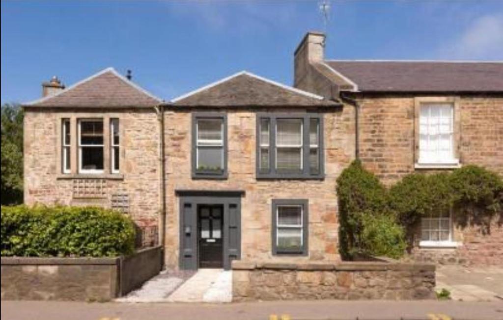 a brick house with a black door on a street at Luxe rooms in Edinburgh