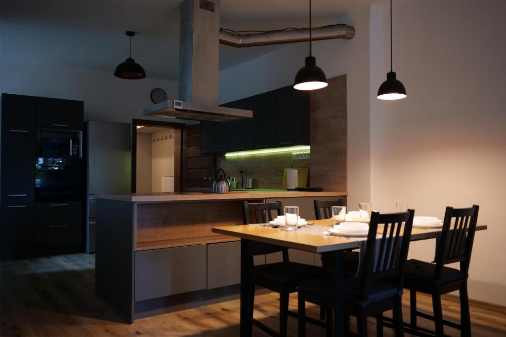 a kitchen with a wooden table with chairs and a counter at Apartman Sysl in Ricany
