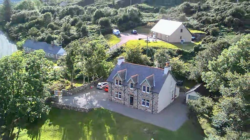 an aerial view of a house in the water at Lochinver Manse in Lochinver
