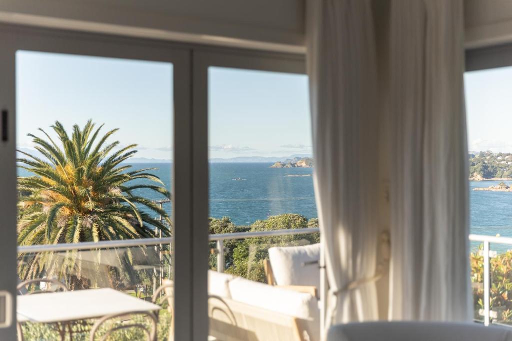 a view of the ocean from a room with a window at The Vintage Cottage in Oneroa