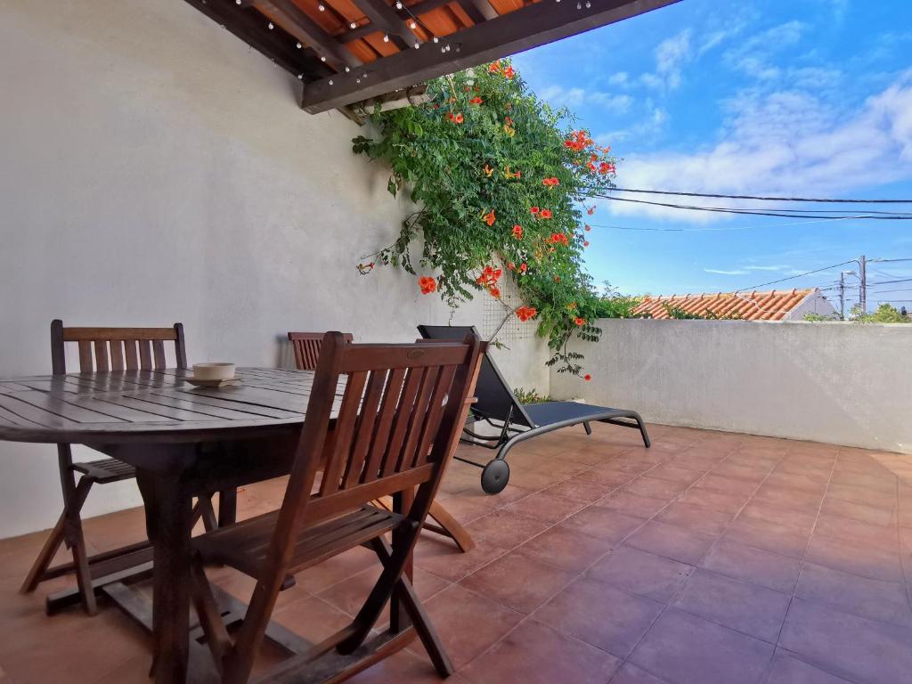 a patio with a table and chairs and a plant at Casa do Terraço by Madrabica in Atouguia da Baleia