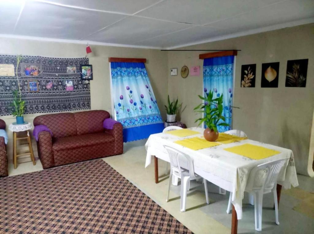 a living room with a table and a couch at JayDees Homestay in Taveuni