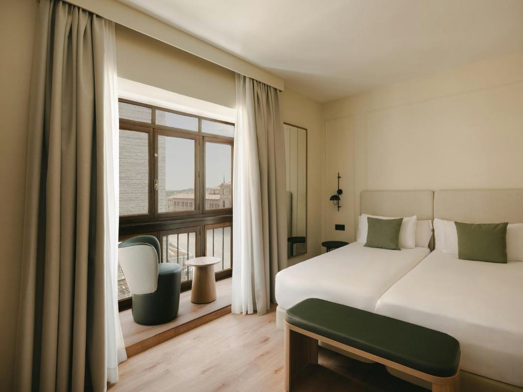 a bedroom with a large bed and a large window at Sercotel Toledo Imperial in Toledo