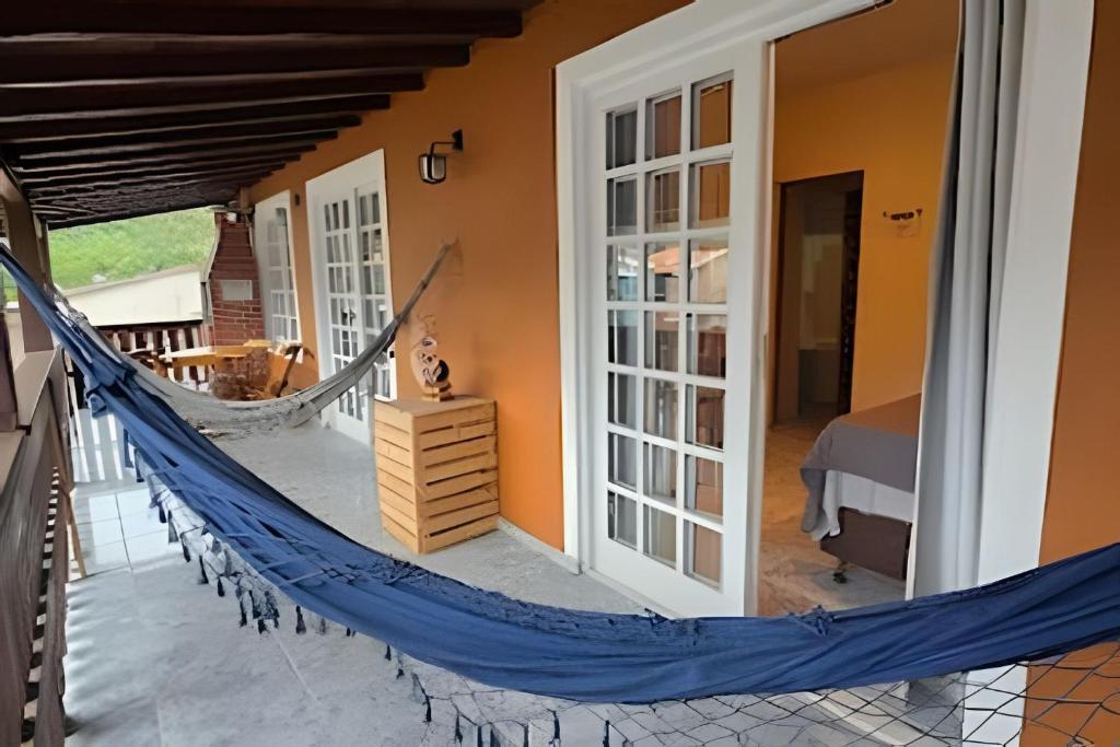 a hammock on the porch of a house at Chalé Private c/ Vista e garagem in Ilhabela