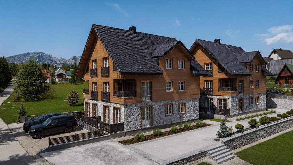 a house with a car parked in front of it at Motherland Chalets in Žabljak
