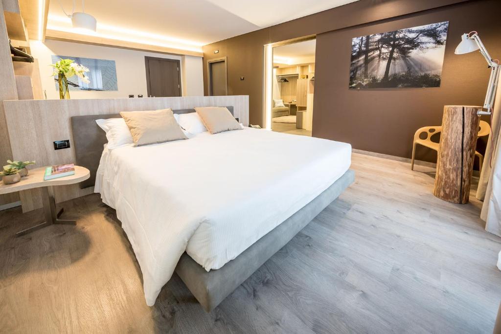Fuori le Mura في ألتامورا: غرفة نوم مع سرير أبيض كبير ومكتب