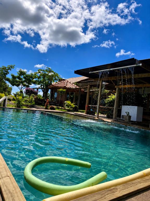 a swimming pool with a green hose in the water at Recanto da Cuesta in Botucatu