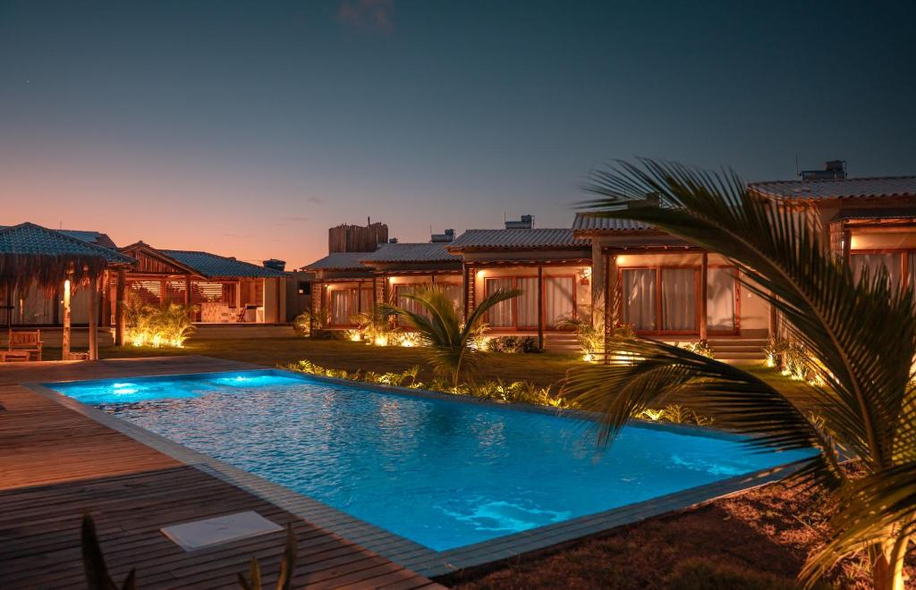 a swimming pool in the yard of a house at night at Falésias Orybá in Corumbau