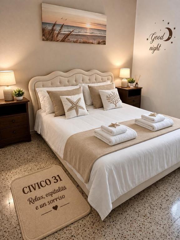 a bedroom with a large bed with two towels on it at Civico 31 in Terralba