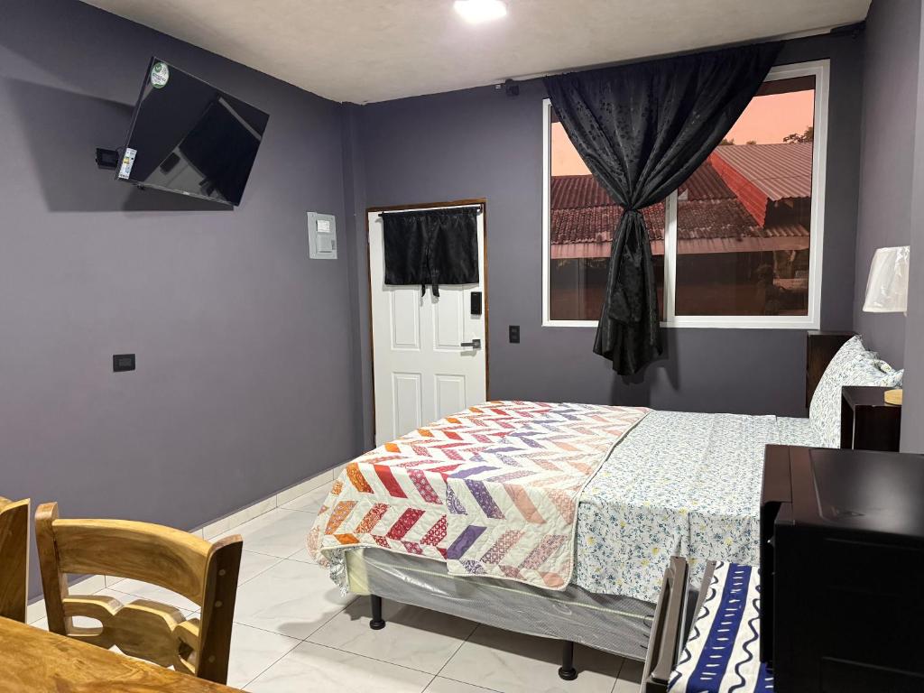 a bedroom with a bed and a window and a tv at El Mangal 4 B&B in Suchitoto