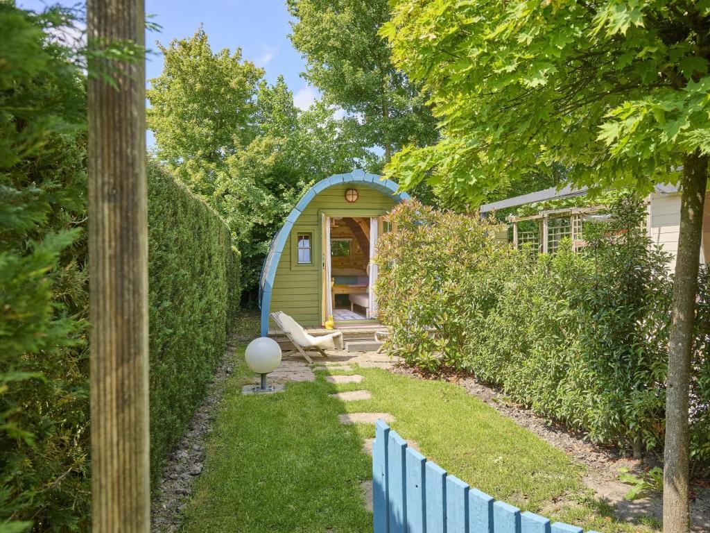 a green shed with a bench in a yard at Tiny House Jet in Goedereede