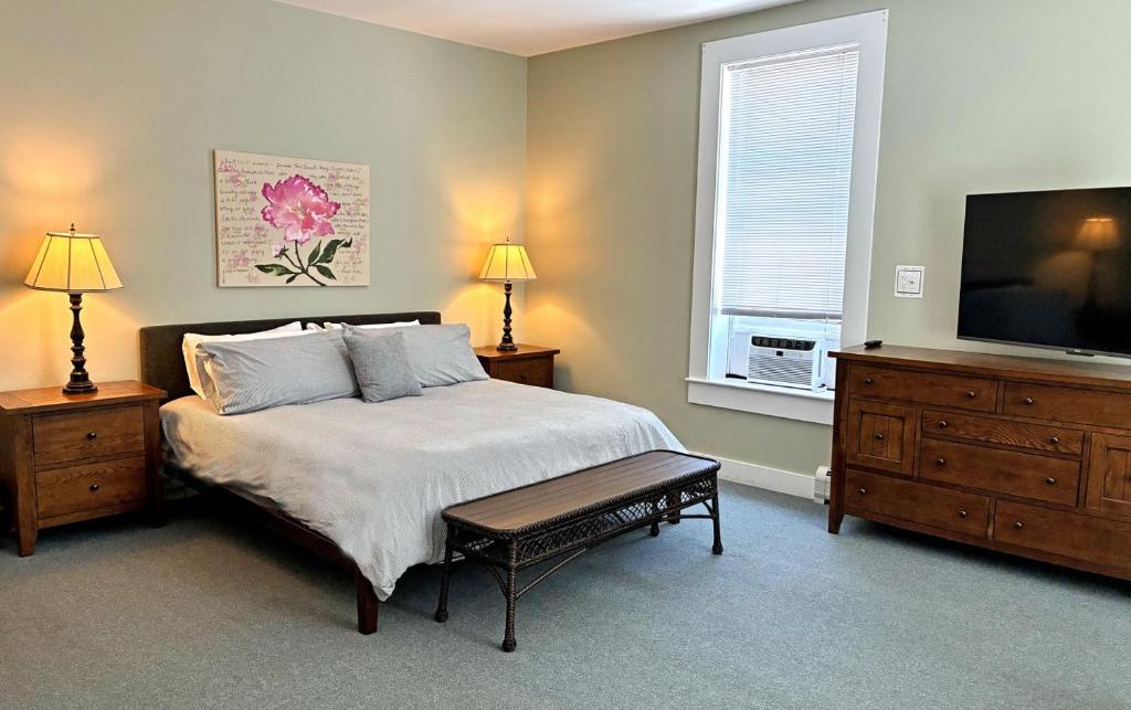a bedroom with a bed and a flat screen tv at Bristol Suites in Bristol