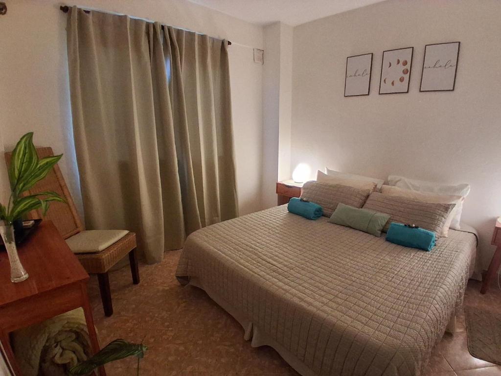 a bedroom with a bed with blue pillows on it at departamento completo, Luminoso, cómodo y bien ubicado ideal eventos river movistar arena tecnopolis in Munro