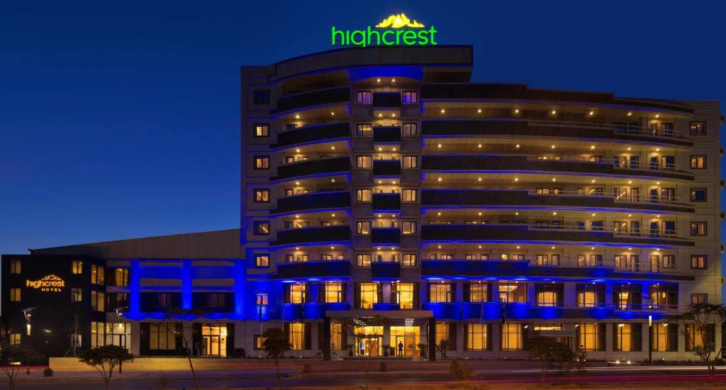 a hotel with a neon sign on top of it at HighCrest Hotel in As Sulaymānīyah