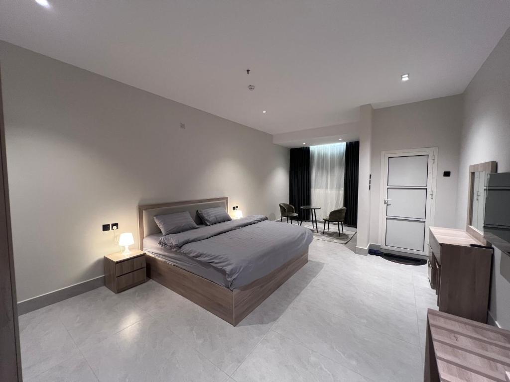 a bedroom with a bed and a living room at الباحه للشقق المخدومه in Al Baha