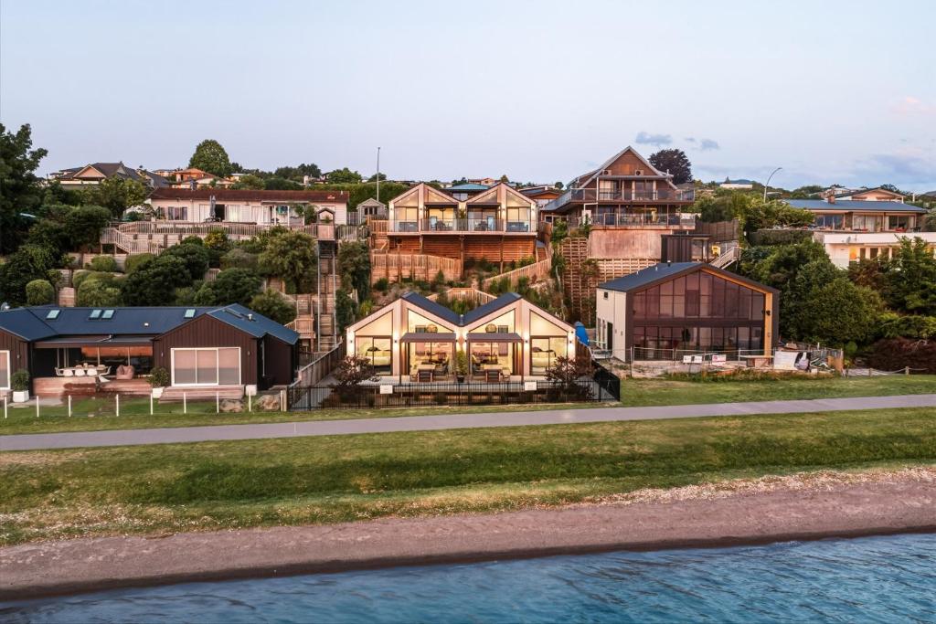 a group of houses on a hill next to a road at Roam Taupo Lake Front Unit 2 - Spa Pool in Taupo