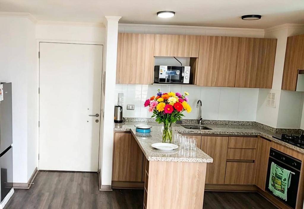 a kitchen with a vase of flowers on a counter at Departamento Centro Iquique in Iquique